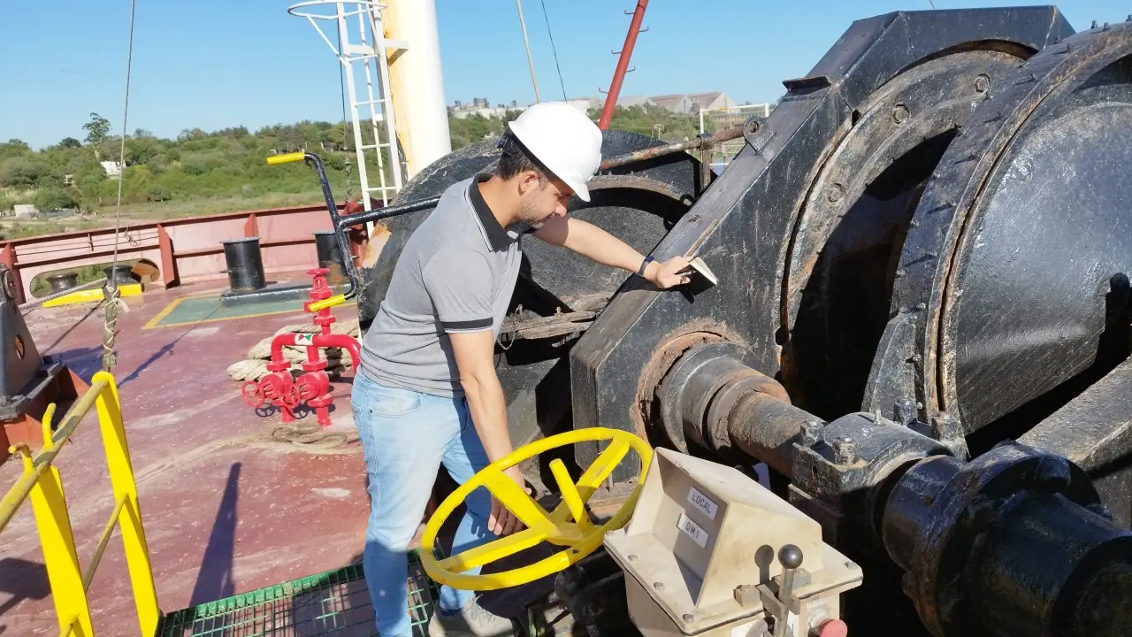 Surveyor sounding a bunker tank on the deck of a vessel