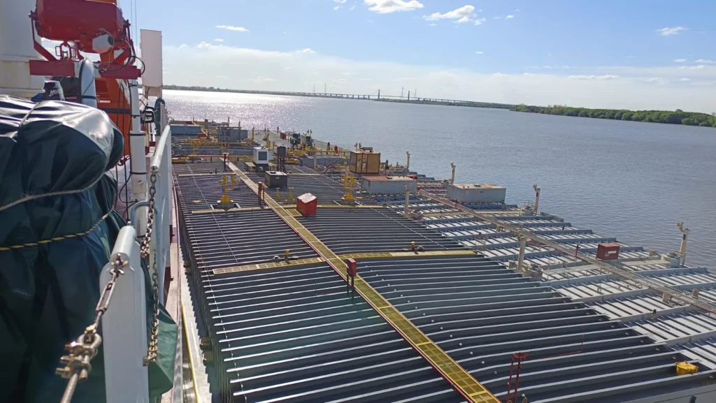 Tank barge convoy on the Paraná river seen from the pusher tug, Rosario–Victoria bridge in the background