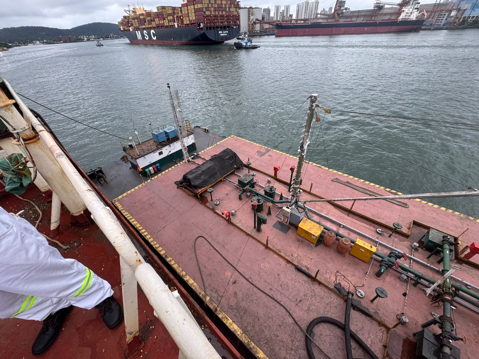 Bunker barge alongside at Santos with container terminal traffic astern